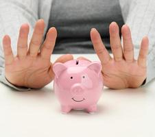 female hands and pink ceramic piggy bank. Accumulation concept, budget control photo