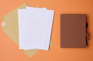 stack of white envelopes on orange background, top view photo