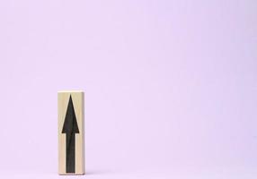 wooden block with an upward arrow on a purple background, the process of growth and achievement of goals, rising prices photo