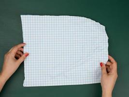 two female hands hold blank sheets of paper in a box photo