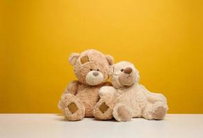 dos linda marrón osito de peluche osos sentado en un amarillo fondo, para niños juguete foto