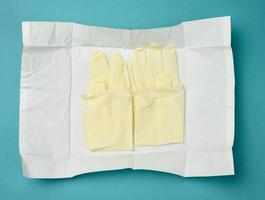 sterile medical white gloves in white paper on a blue background photo