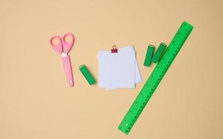 conjunto de papelería objetos gobernante, blanco blanco papel hojas en un beige antecedentes. ver desde arribaverde foto