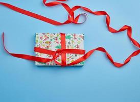 gift wrapped in multi-colored paper on a blue background photo