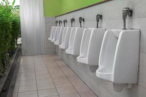 fila de al aire libre urinario hombres público baño blanco urinarios en hombres baño foto