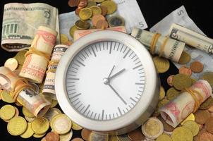 Coins, banknotes and a clock photo