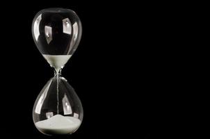 Hourglass on black background photo