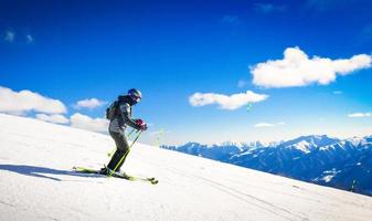 Young woman skier ride downhill carve close up in mountains in fast freeze motion steep downhill solo photo