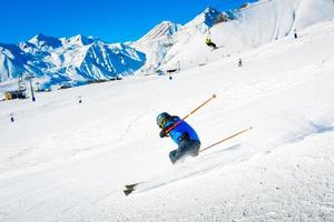 Esquiador masculino esquí cuesta abajo ascensor de cabina de paso rápido en condiciones de nieve a góndola con fondo de montañas. complejo de vacaciones de invierno de gudauri. destino de viaje de georgia. Cáucaso foto