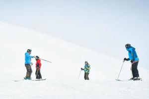 Gudauri, Georgia, 2022- Caucasian male ski instructor teaching to ski family two kids and father beginner skier in Gudauri ski resort. Ski holiday in Georgia photo