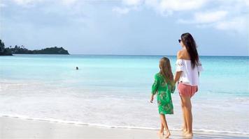 lindo mãe e filha em caribe de praia. família em de praia período de férias. lento movimento video