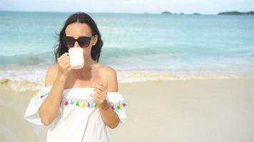 joven mujer con taza de té en el playa video