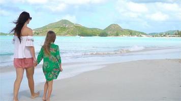 lindo mãe e filha em caribe de praia. família em de praia período de férias. lento movimento video