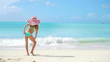 Adorable little girl in big hat on the beach. Happy kid enjoy summer vacation video