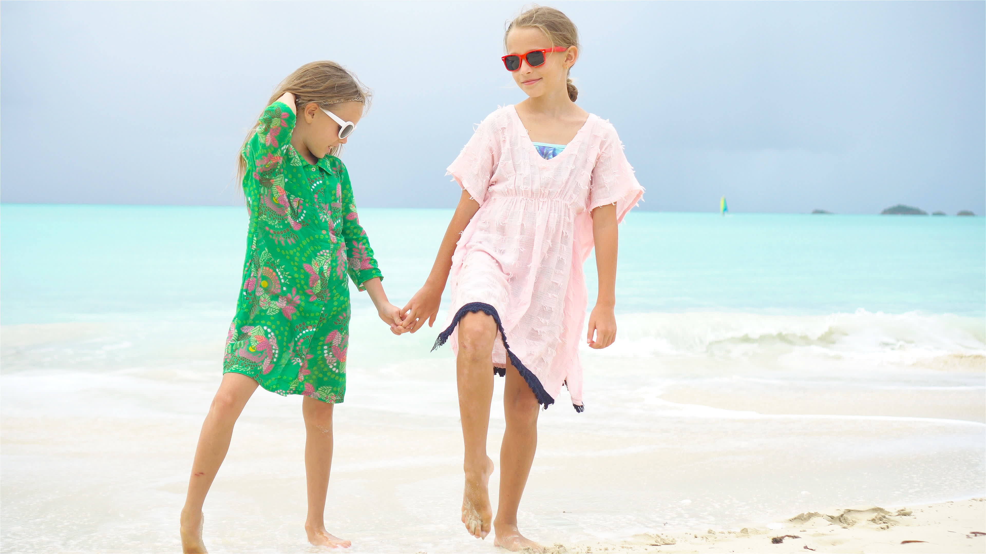 Adorable little girl having a lot of fun at tropical beach playing