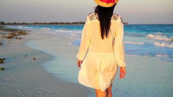 magnifique femme sur été vacances sur blanc plage. content fille en marchant dans été robe. lent mouvement video