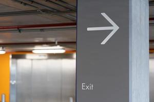 Arrow pointing to the exit on the pole. Exit Sign, Metal Exit Sign, Parking Exit in Condo. Symbol. copy space. selective focus. photo