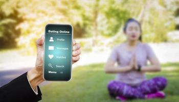 Hand hold smartphone with health app on the screen. All screen graphics are made up, health app while walking in nature park, Exercise for health or warm-up body, Oxygen in the green tree in the park photo