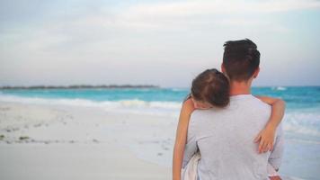 Father and his adorable little daughter at white beach. Family walking in sunset on the seashore video