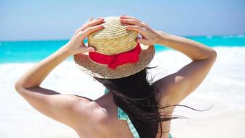 terug visie van mooi vrouw in hoed Aan zomer vakantie Aan wit strand. video
