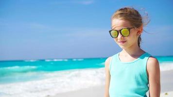 liten flicka på de vit strand. porträtt av förtjusande unge på henne sommar tropisk högtider video