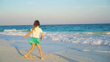 Adorable happy little girl on white beach at sunset video