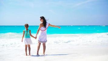 Little adorable girl and young mother at tropical beach video