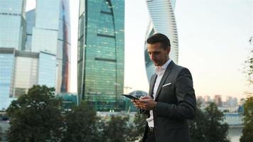 jeune homme caucasien tenant un smartphone pour le travail d'entreprise. video