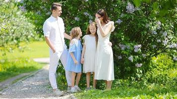 Family of four in blooming garden on beautiful spring day video