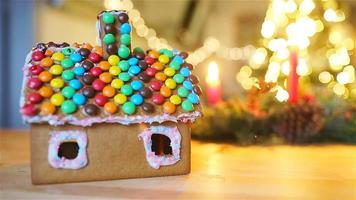 Gingerbread fairy house on a background of bright Christmas tree with garland video