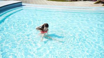 adorable pequeño niña nadar en al aire libre nadando piscina video