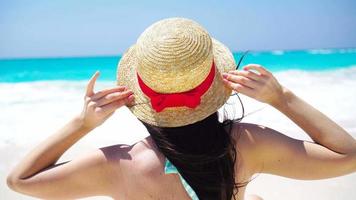 indietro Visualizza di bellissimo donna nel cappello su estate vacanze su bianca spiaggia. video