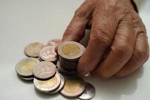 anciana jubilada que cuenta monedas y se preocupa por los gastos mensuales y el pago de la tarifa de tratamiento. foto