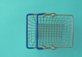 Empty shopping basket on colorful background. Shop trolley at supermarket. Sale, discount, shopaholism, black friday, economy concept. Consumer society trend. Online Shopping Concept. photo