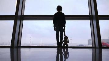 Little girl in airport near big window while wait for boarding video
