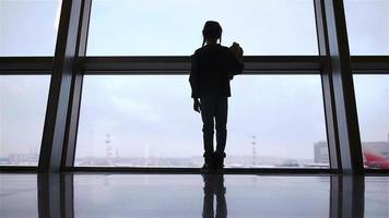 Little girl in airport near big window while wait for boarding video