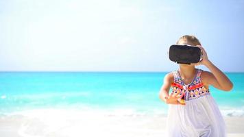 Cute little child girl using VR virtual reality goggles video