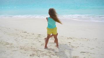 Adorable little girls have fun together on white tropical beach video