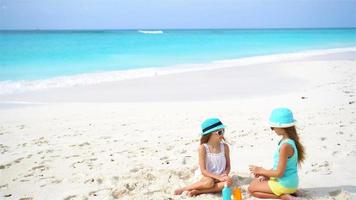Kinder tragen Sonnencreme am Strand auf. das Konzept des Schutzes vor ultravioletter Strahlung