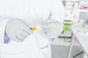 a doctor or laboratory scientist holding a syringe containing liquid vaccine photo