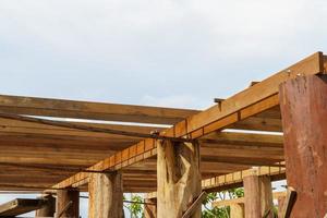 A wooden frame structure with massive supporting pillars prepares the construction of a two-story house. photo