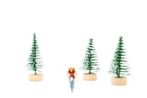 Miniature people with gifts on a bicycle on white background photo