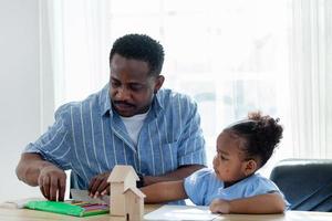 happy family african father and daughter Coloring together. Homeschool concept, happy family. photo