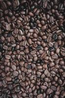 granos de café tostados, fondo marrón foto