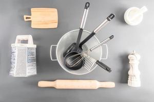 varios cocina utensilios hecho de madera, metal, cerámica en un gris antecedentes. parte superior vista. plano poner. foto