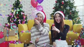 zwei asiatische frau feiern weihnachtsfeier freudig mit festlichen wunderkerzen. video