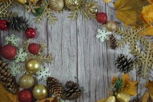 Red and gold Christmas ornament corner border banner. Above view on a rustic wood background. photo