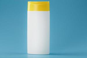 A white shampoo and shower gel bottle with a yellow lid. photo