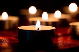 Candle light and red fabric background in the darkness with space for text or image. valentine love concept photo