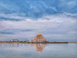 Makassar,Indonesia,31 Juni 2021-A modern mosque building in the middle of the sea with a blue sky and white clouds photo